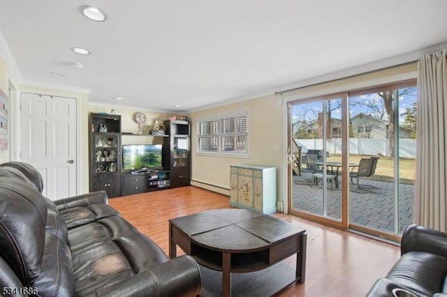 living area featuring a baseboard radiator, wood finished floors, and crown molding