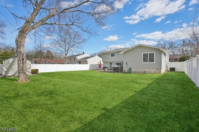 rear view of house with a patio area, a yard, cooling unit, and a fenced backyard