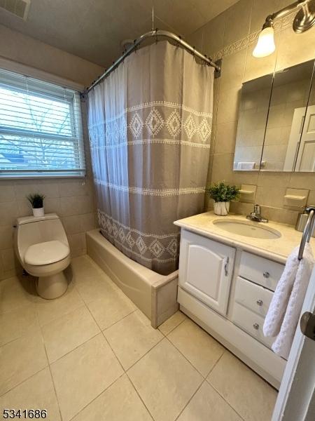 full bath featuring vanity, tile walls, toilet, and tile patterned floors