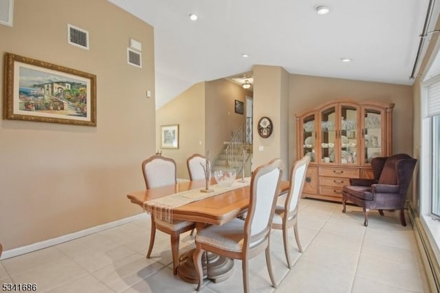 dining space with lofted ceiling, visible vents, stairway, and light tile patterned flooring