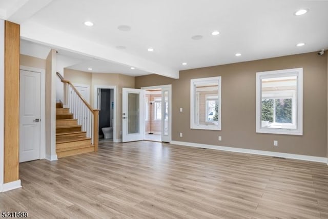 unfurnished room with light wood-type flooring, stairs, and recessed lighting