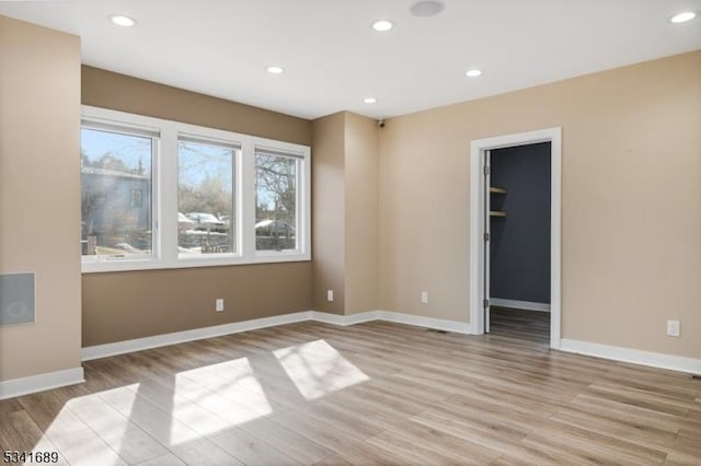 empty room featuring recessed lighting, light wood-style flooring, and baseboards