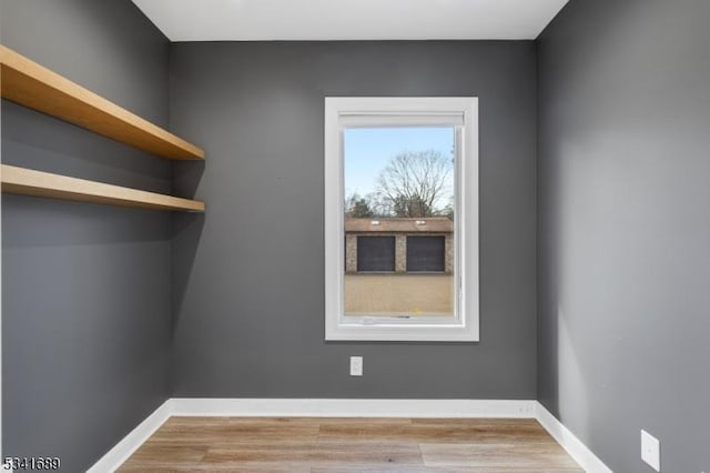 spare room with baseboards and wood finished floors