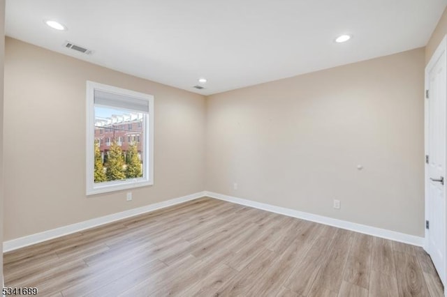 empty room with recessed lighting, visible vents, light wood-style flooring, and baseboards