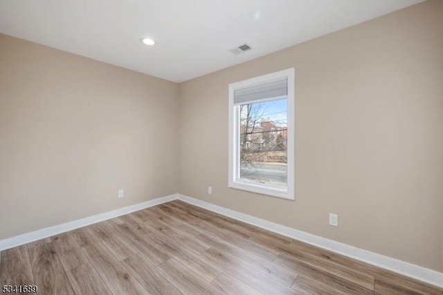 unfurnished room featuring baseboards, visible vents, light wood-style flooring, and recessed lighting