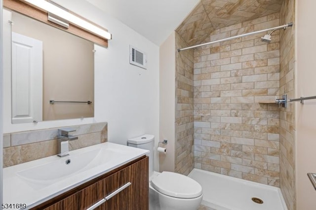 bathroom featuring toilet, a stall shower, vanity, and visible vents