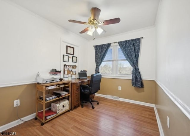 office space featuring baseboards, visible vents, a ceiling fan, ornamental molding, and wood finished floors