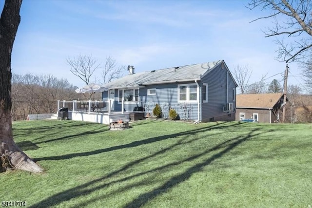 back of property featuring a lawn and a deck