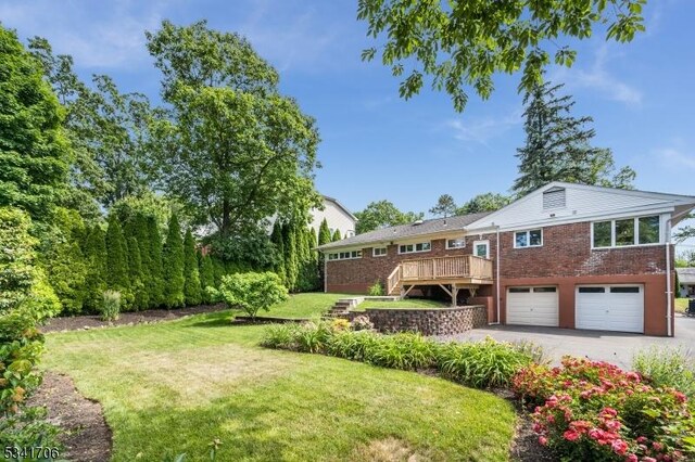 view of yard with driveway, stairway, and an attached garage