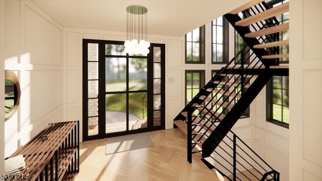 interior space featuring stairway, a decorative wall, and a notable chandelier