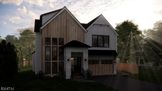 view of front facade with driveway, brick siding, and an attached garage