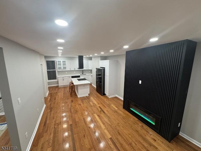 299 Halladay St, Jersey City, NJ 07304 - kitchen with a fireplace, white cabinets, light countertops, wood finished floors, and recessed lighting