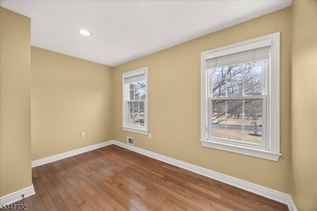 spare room with dark wood-style floors, recessed lighting, visible vents, and baseboards