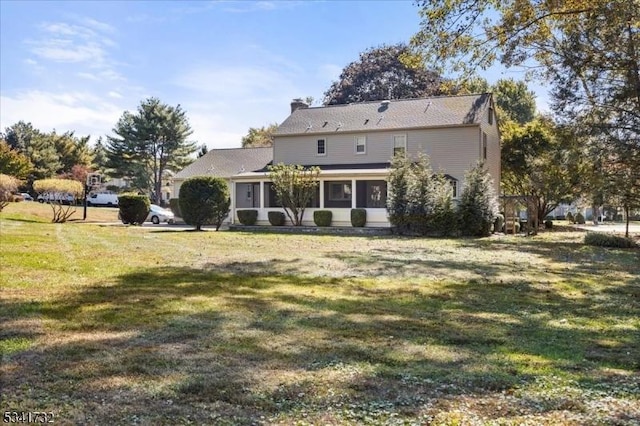 rear view of house with a yard and a chimney