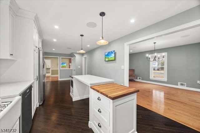 kitchen featuring a center island, black dishwasher, dark wood-type flooring, white cabinets, and wood counters