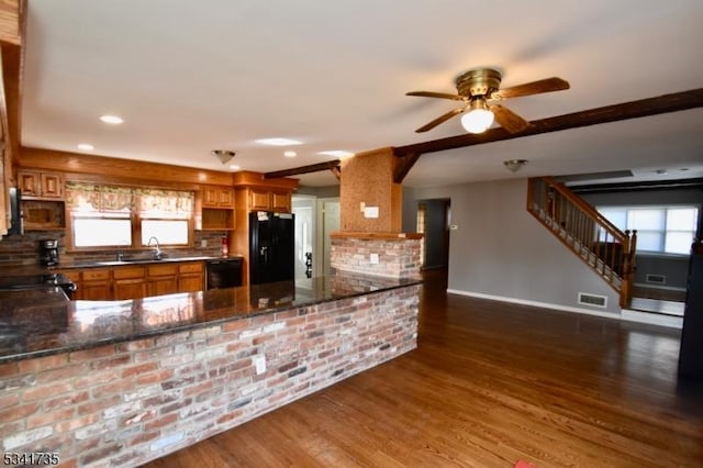 kitchen featuring tasteful backsplash, baseboards, dark wood-style floors, brown cabinets, and black appliances