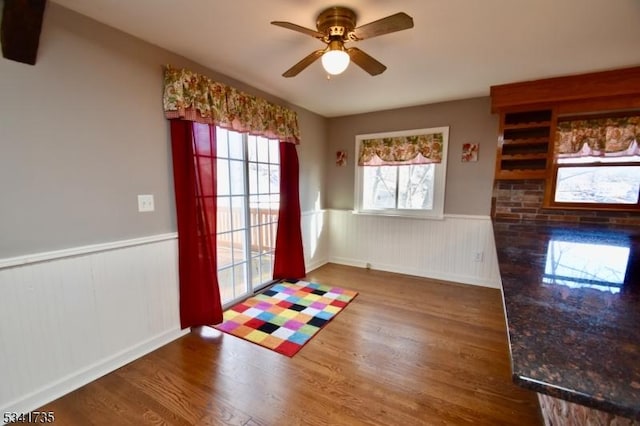 entryway featuring wainscoting, ceiling fan, and wood finished floors