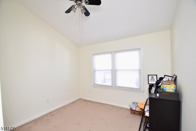 interior space with lofted ceiling, baseboards, a ceiling fan, and light colored carpet