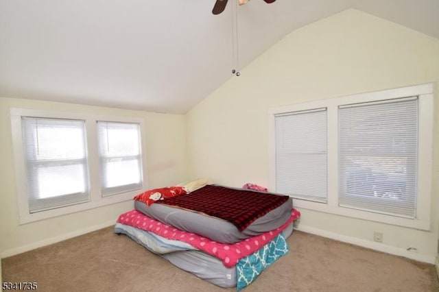 carpeted bedroom featuring ceiling fan, baseboards, and vaulted ceiling