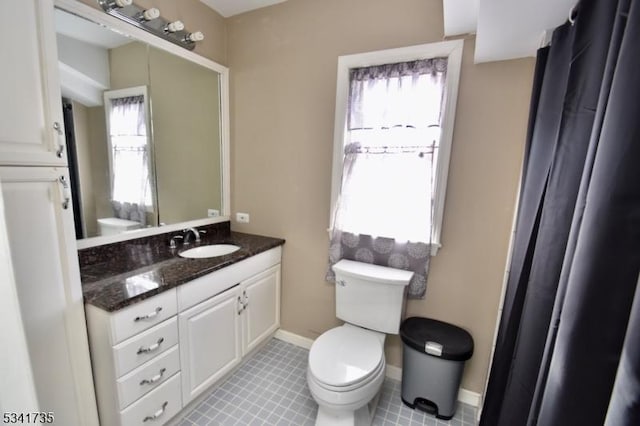 full bathroom with toilet, baseboards, and vanity