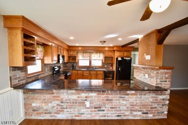 kitchen with a peninsula, black appliances, and a healthy amount of sunlight