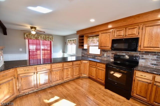 kitchen with brown cabinets, black appliances, light wood-style flooring, and tasteful backsplash