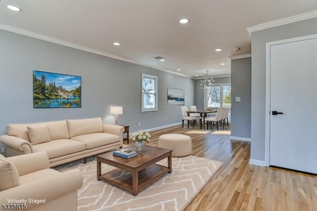 living room featuring ornamental molding, light wood-type flooring, baseboards, and recessed lighting