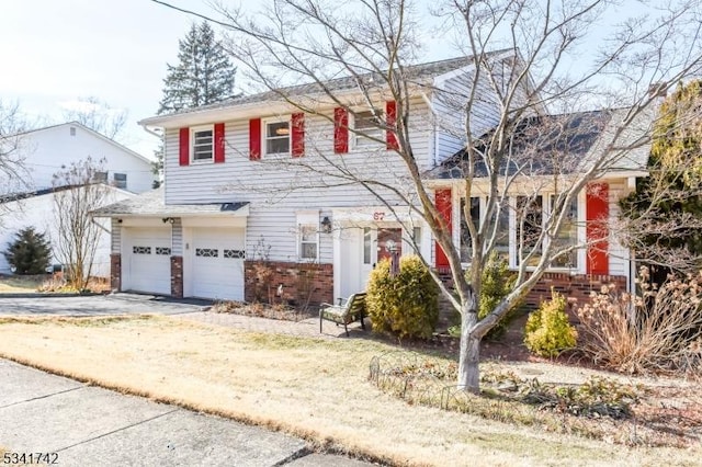 split level home with driveway, a garage, and brick siding