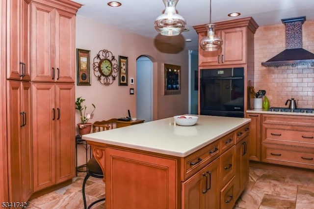 kitchen featuring arched walkways, tasteful backsplash, light countertops, black oven, and wall chimney exhaust hood