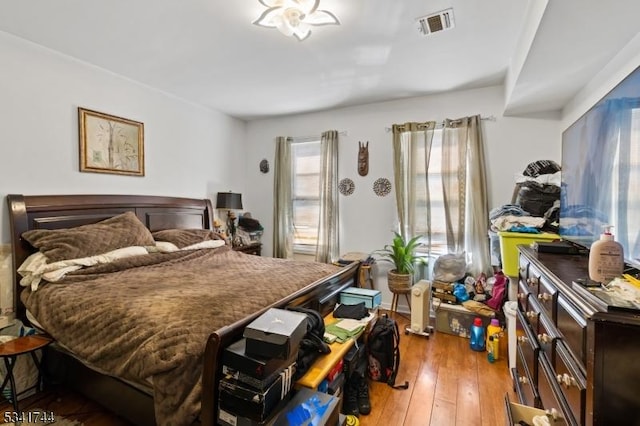 bedroom with visible vents and hardwood / wood-style flooring