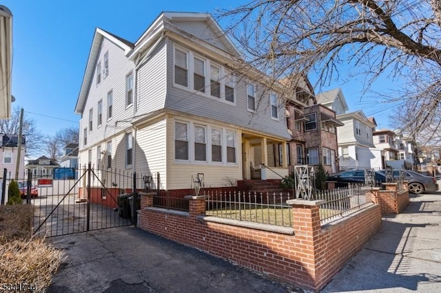 view of front facade featuring a fenced front yard, a residential view, and a gate