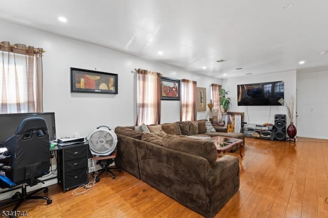 living area featuring recessed lighting, visible vents, and wood-type flooring