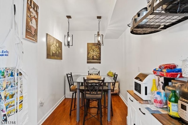 dining room with baseboards and dark wood-style flooring