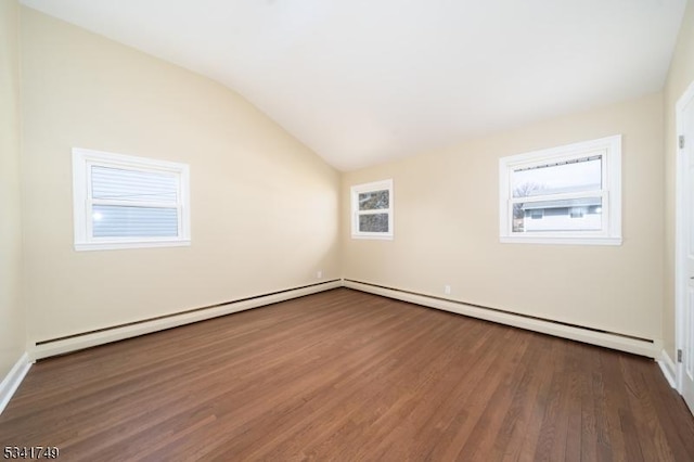 empty room with lofted ceiling, a baseboard heating unit, and dark wood-style flooring