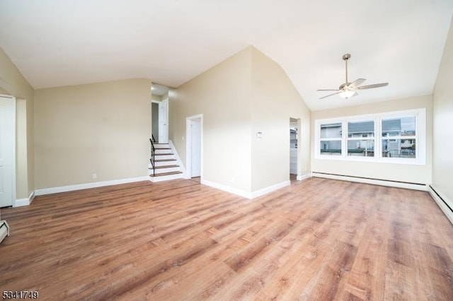 unfurnished living room featuring a baseboard heating unit, lofted ceiling, stairway, and wood finished floors