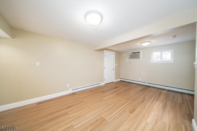 empty room with a wall unit AC, light wood-style floors, a baseboard radiator, and baseboards