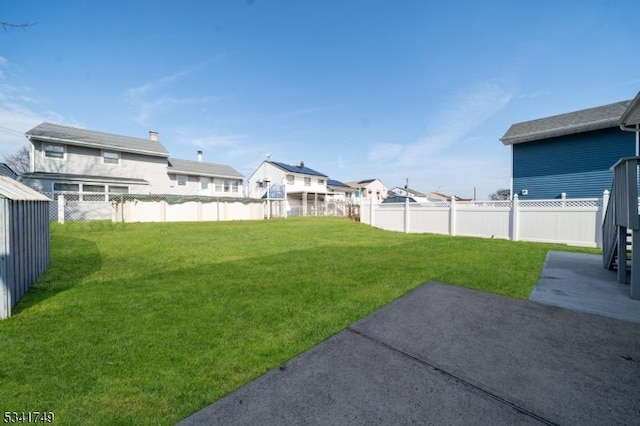 view of yard with a fenced backyard, a residential view, and a patio