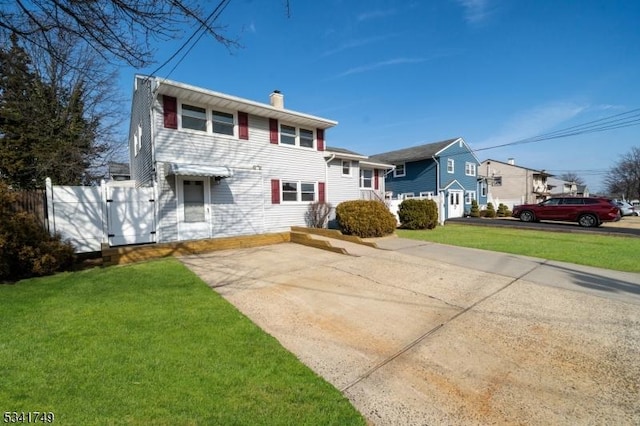 view of front of house featuring a front lawn, a chimney, fence, and a gate