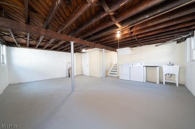 below grade area with plenty of natural light, stairs, washer and clothes dryer, and a sink