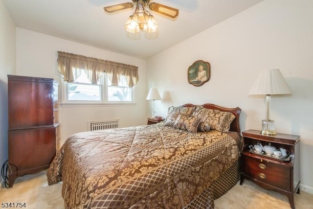 carpeted bedroom with radiator heating unit, baseboards, and a ceiling fan