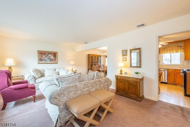 living area with light carpet, visible vents, and a chandelier