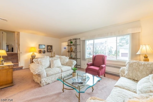 carpeted living area featuring stairway, radiator heating unit, and visible vents