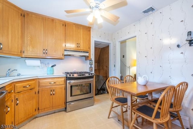 kitchen with stainless steel appliances, visible vents, a sink, under cabinet range hood, and wallpapered walls