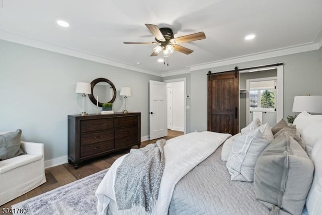 bedroom with a barn door, wood finished floors, a ceiling fan, baseboards, and ornamental molding