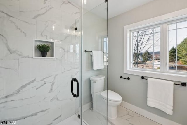 bathroom with marble finish floor, a marble finish shower, toilet, and baseboards