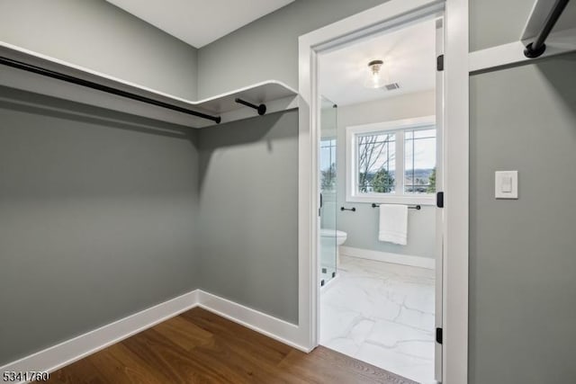 walk in closet with marble finish floor and visible vents