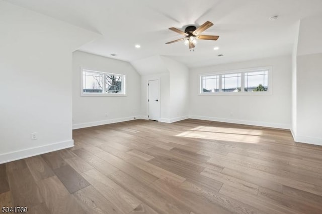 interior space with ceiling fan, recessed lighting, wood finished floors, baseboards, and vaulted ceiling