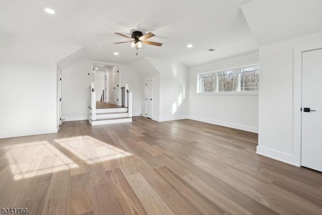 additional living space featuring recessed lighting, wood finished floors, a ceiling fan, baseboards, and stairs