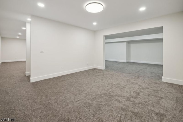 finished basement featuring baseboards, dark colored carpet, and recessed lighting