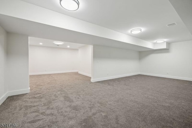 finished basement with carpet, visible vents, and baseboards